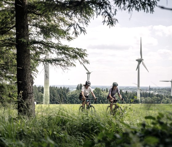 Gravelbiker vor Windrädern in Eifellandschaft, © StädteRegion Aachen
