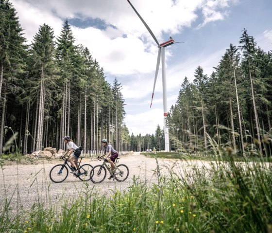 Gravelbiker vor Windrad im Wald, © StädteRegion Aachen